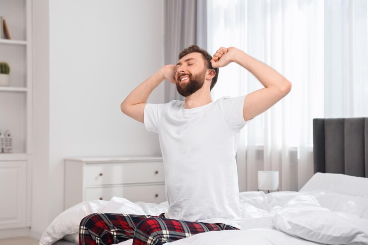 young-man-stretching-bed-morning